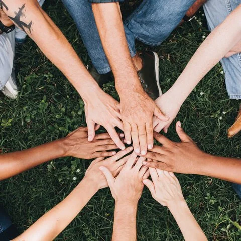 volunteer putting hands together for a cause